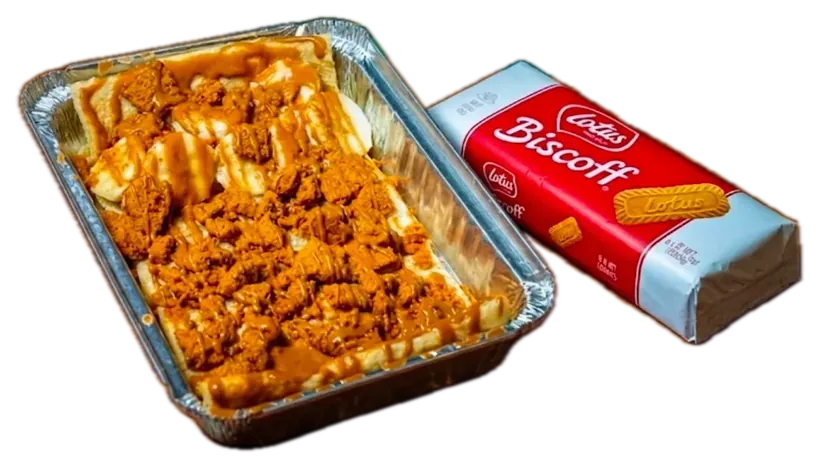 A HalAli's Biscoff crepe in a foil tray, topped with banana and crushed Lotus Biscoff, beside a pack of Biscoff biscuits.